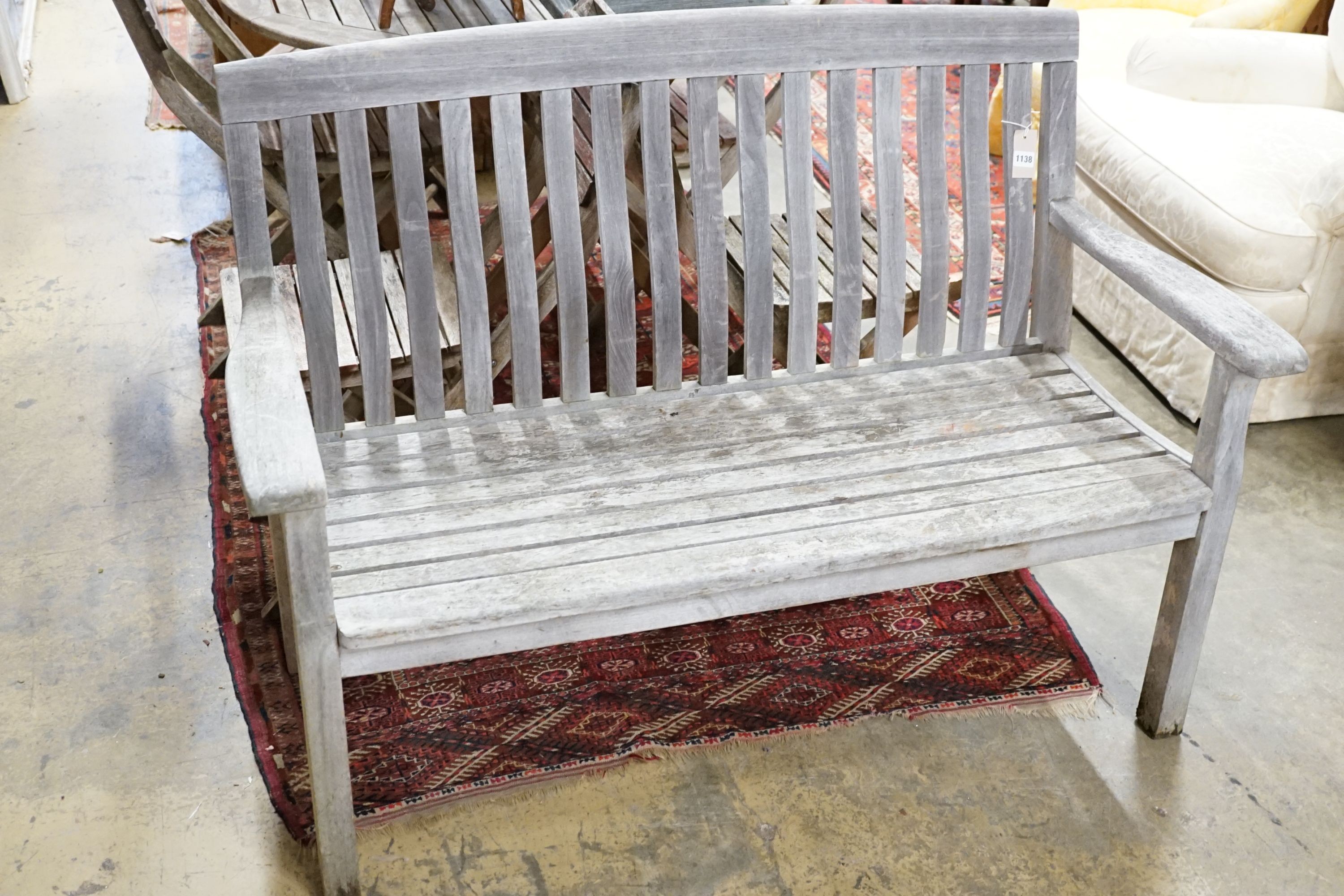 A weathered teak garden bench, length 129cm
